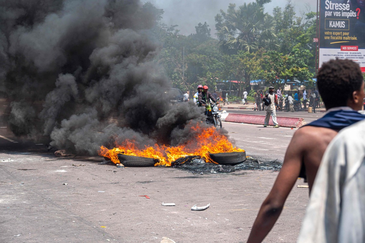 Burning tires block a road during a demonstration against the escalating conflict in eastern Democratic Republic of Congo in Kinshasa, on January 28, 2025. (Photo by Hardy BOPE / AFP)
