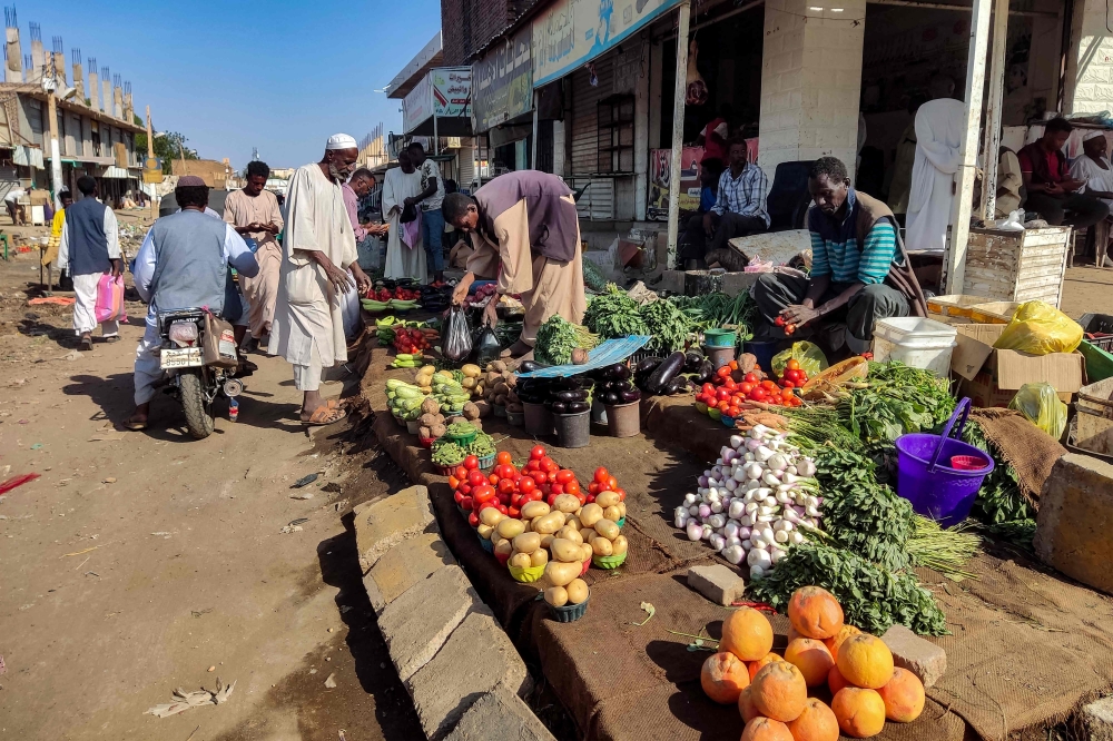 Street vendors sell their fruits and vegetables at a market in Wad Madani in Sudan's al-Jazira state on February 20, 2025. (Photo by AFP)