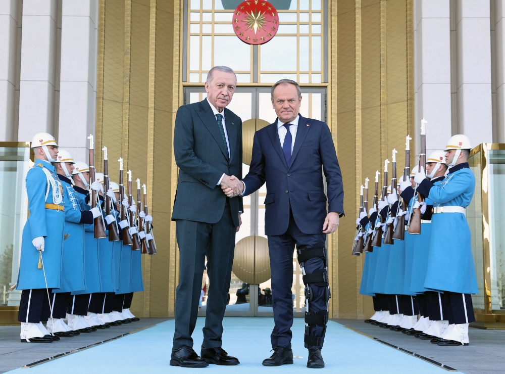 This handout photograph taken and released by Turkish Presidency Press Office on March 12, 2025, shows Turkey's President Recep Tayyip Erdogan (left) welcoming Poland's Prime Minister Donald Tusk prior to their meeting at the Presidential Complex in Ankara. (Photo by HANDOUT / Turkish Presidency Press Office / AFP)
