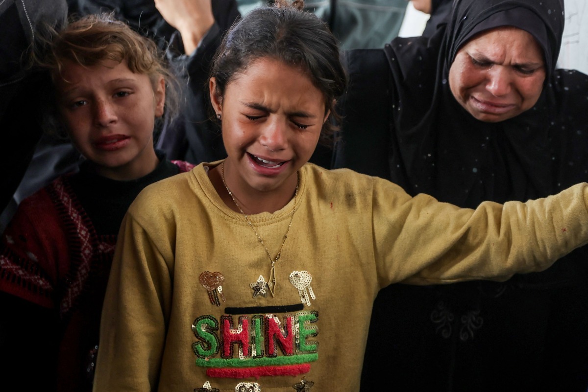 People cry as Palestinians mourn over the bodies of loved ones killed in overnight Israeli bombardment on northen Gaza, at the Ahli Arab Hospital, also known as the Maamadani (Baptist) Hospital, in Gaza City on April 3, 2025. (Photo by Omar AL-QATTAA / AFP)