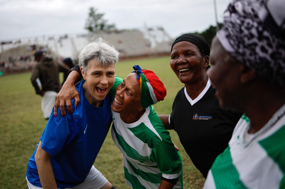 South African Vuka Soweto team players interact with a French team member after their quarter final match during the Grannies International Football Tournament 2025 at Nkowankowa stadium in Tzaneen on April 4, 2025. (Photo by Phill Magakoe / AFP)