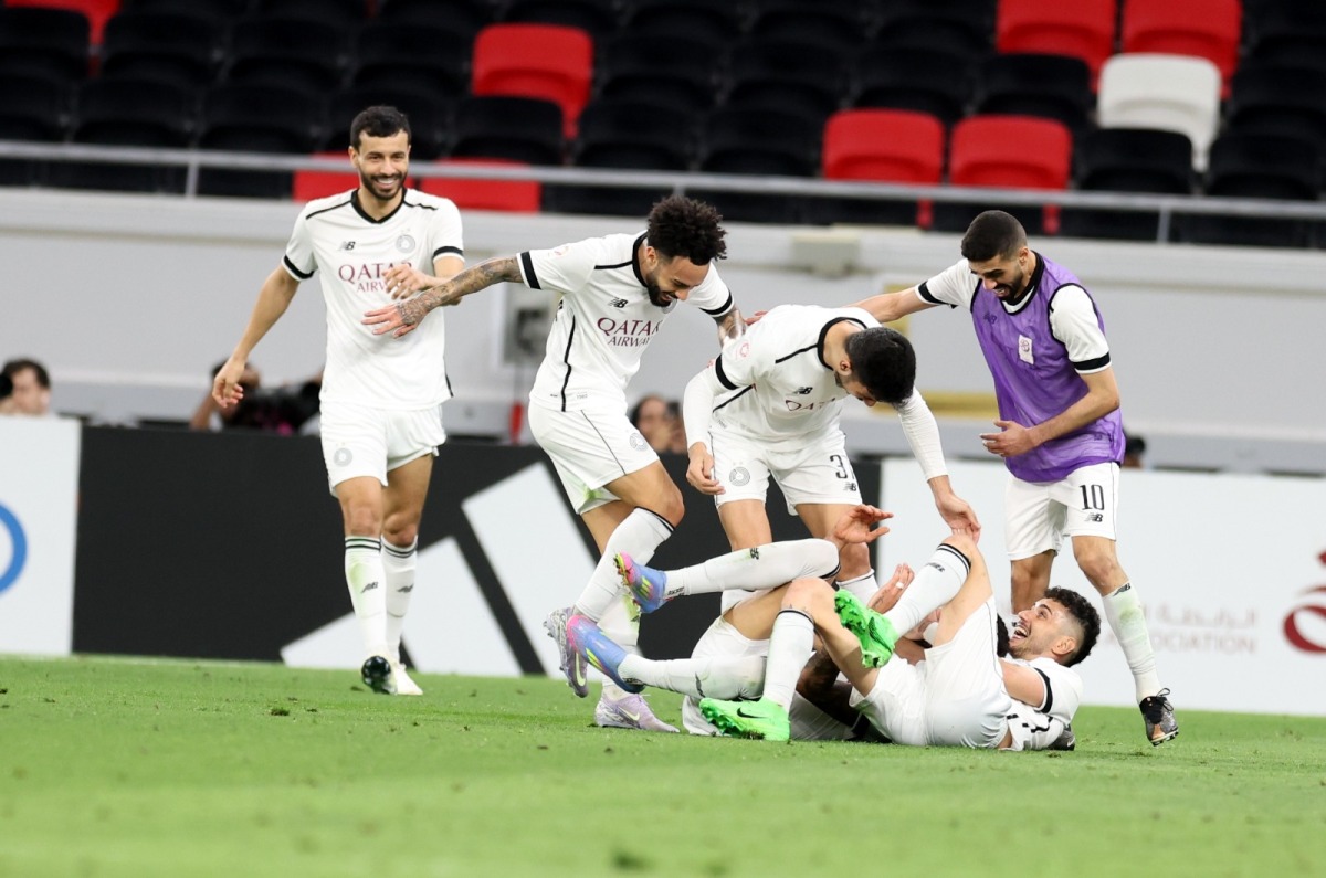 Al Sadd players celebrate Rafa Mujica's equaliser against Al Rayyan.