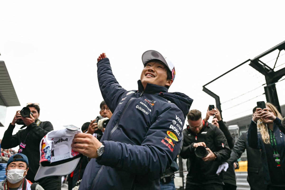 Red Bull Racing's Japanese driver Yuki Tsunoda tosses a cap to the fans during the drivers' parade before the start of the Formula One Japanese Grand Prix at the Suzuka circuit in Suzuka, Mie prefecture, Japan on April 6, 2025. (Photo by MOHD RASFAN / AFP)