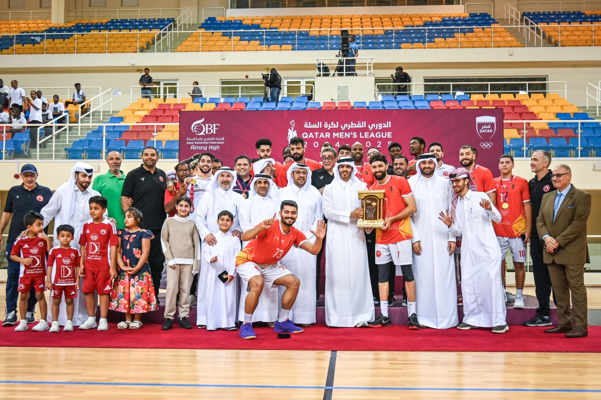 Qatar Basketball Federation President Mohammed Saad Al Mughaiseeb presents the winners' trophy to Al Arabi captain.
