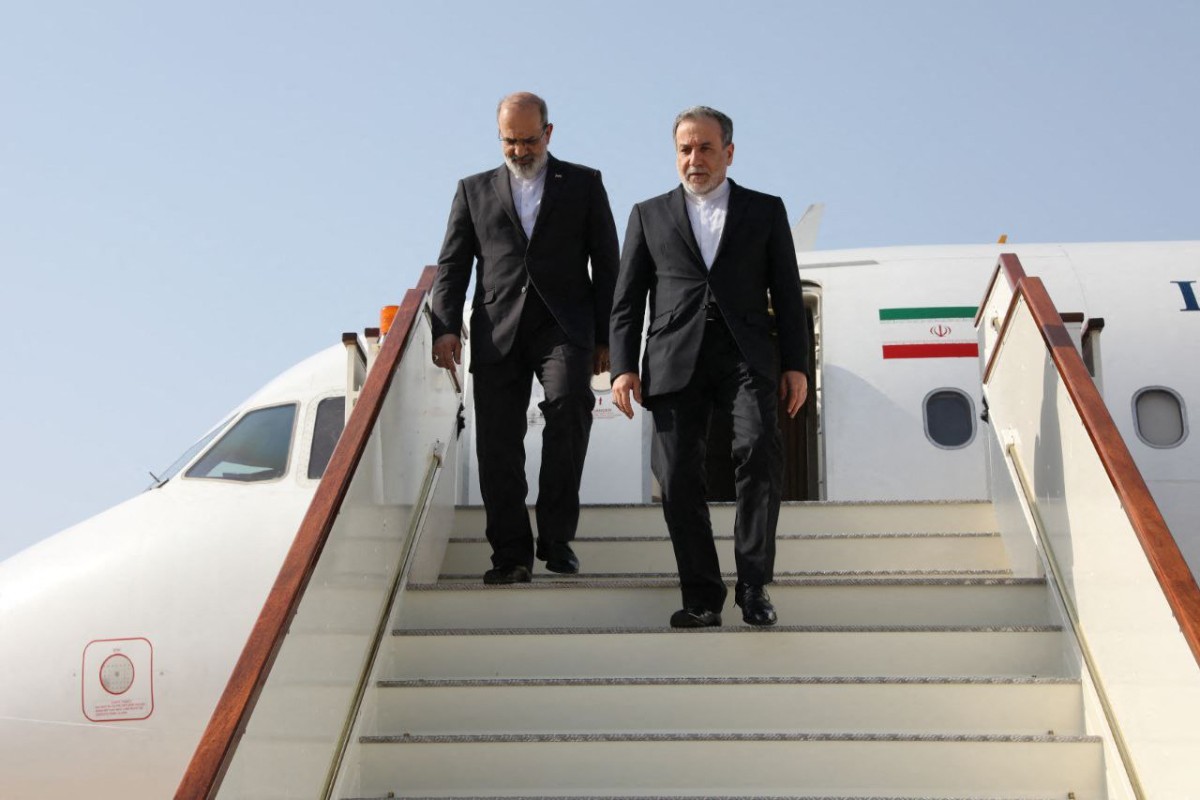 This handout picture provided by the Iranian Foreign Ministry shows Iran's Foreign Minister Abbas Araghchi (R) descending the stairs of his plane upon his arrival in Muscat on April 25, 2025. (Photo by Iranian Foreign Ministry / AFP)