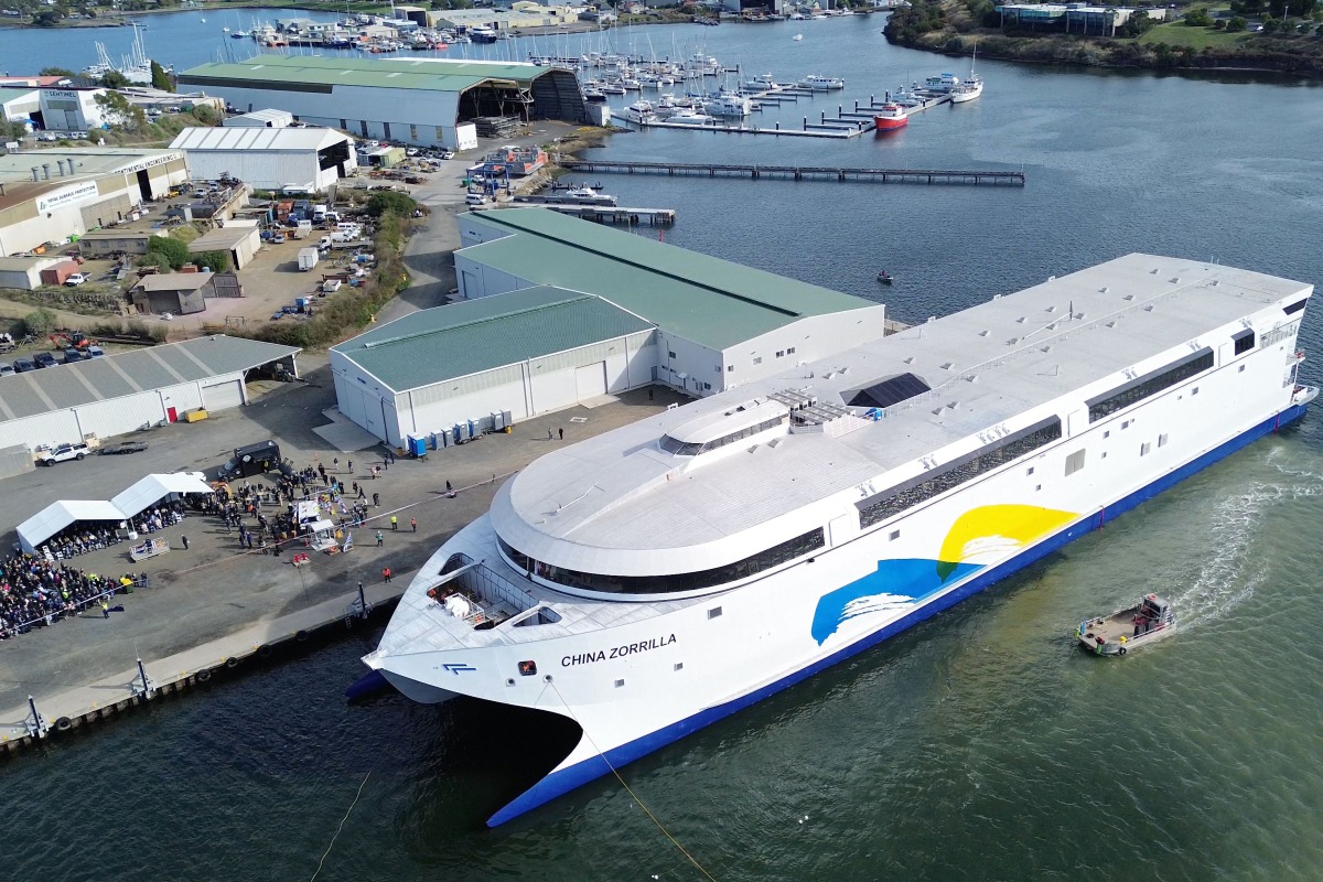 This handout photo taken and released on May 2, 2025 by Incat Tasmania shows an aerial view of the launch of the Hull 096 aluminium catamaran, the world's largest battery-electric ship, at the Incat shipyard in Hobart in Australia's island state of Tasmania. Photo by Handout / Incat Tasmania / AFP