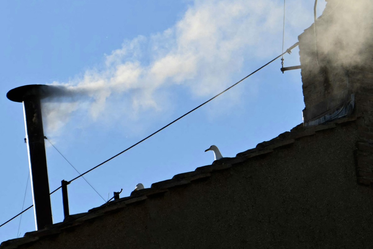 This photograph shows white smoke rising from the chinmey of the Sistine Chapel signaling that cardinals elected a new pope during their conclave in the Vatican on May 8, 2025. (Photo by Alberto PIZZOLI / AFP)
