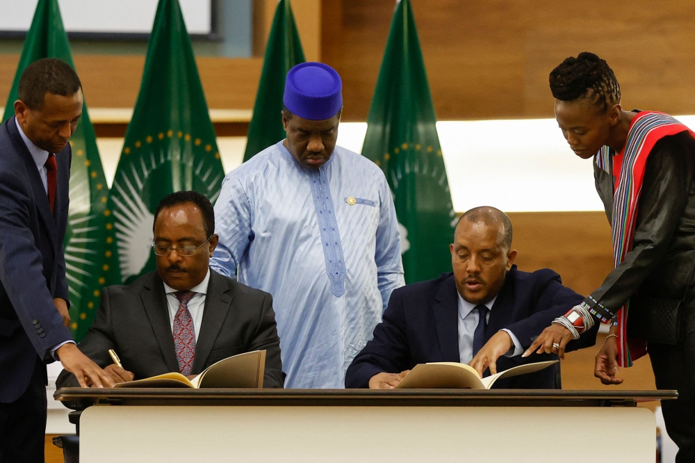 In this file photo taken on November 02, 2022 Redwan Hussein (2nd L), Representative of the Ethiopian government, and Getachew Reda (2nd R), Representative of the Tigray People's Liberation Front (TPLF), sign a peace agreement between the two parties during a press conference regarding the African Union-led negotiations to resolve conflict in Ethiopia at the Department of International Relations and Cooperation (DIRCO) offices in Pretoria.(Photo by PHILL MAGAKOE / AFP)

