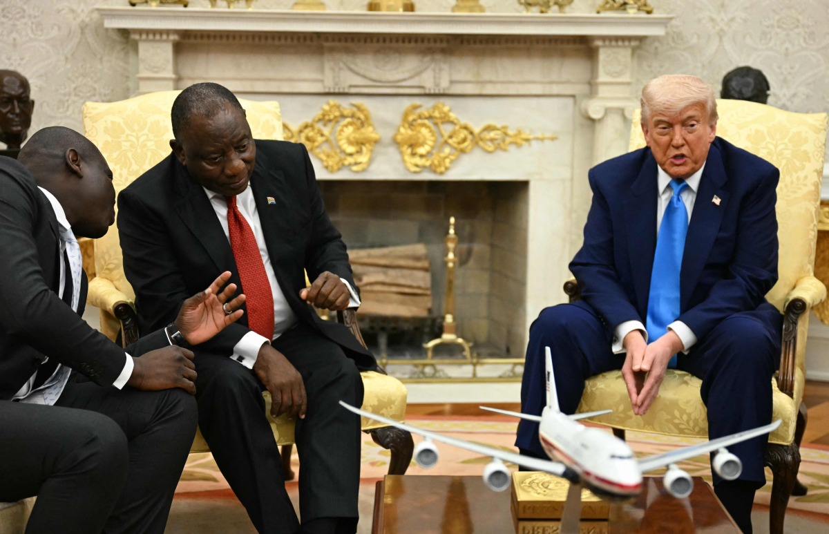 US President Donald Trump speaks as South African President Cyril Ramaphosa speaks with a member of his delegation in the Oval Office of the White House in Washington, DC, on May 21, 2025. (Photo by Jim WATSON / AFP)