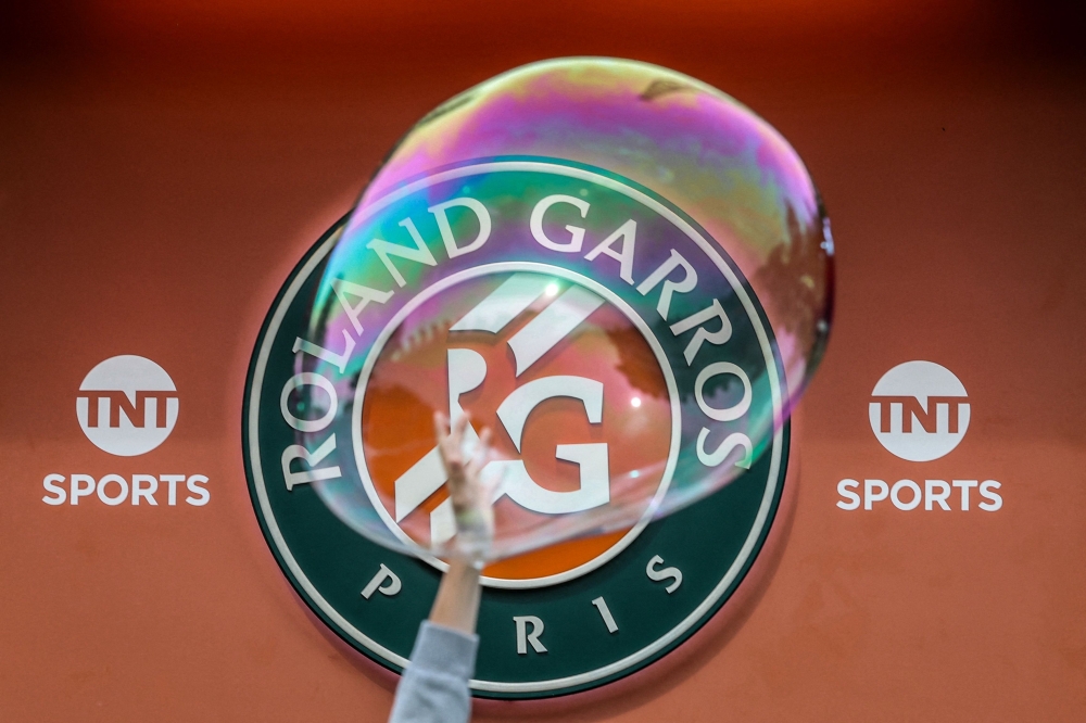 A visitor plays with a soap bubble during the French Open tennis tournament at the Roland-Garros Complex in Paris on May 24, 2025. (Photo by Alain Jocard / AFP)
