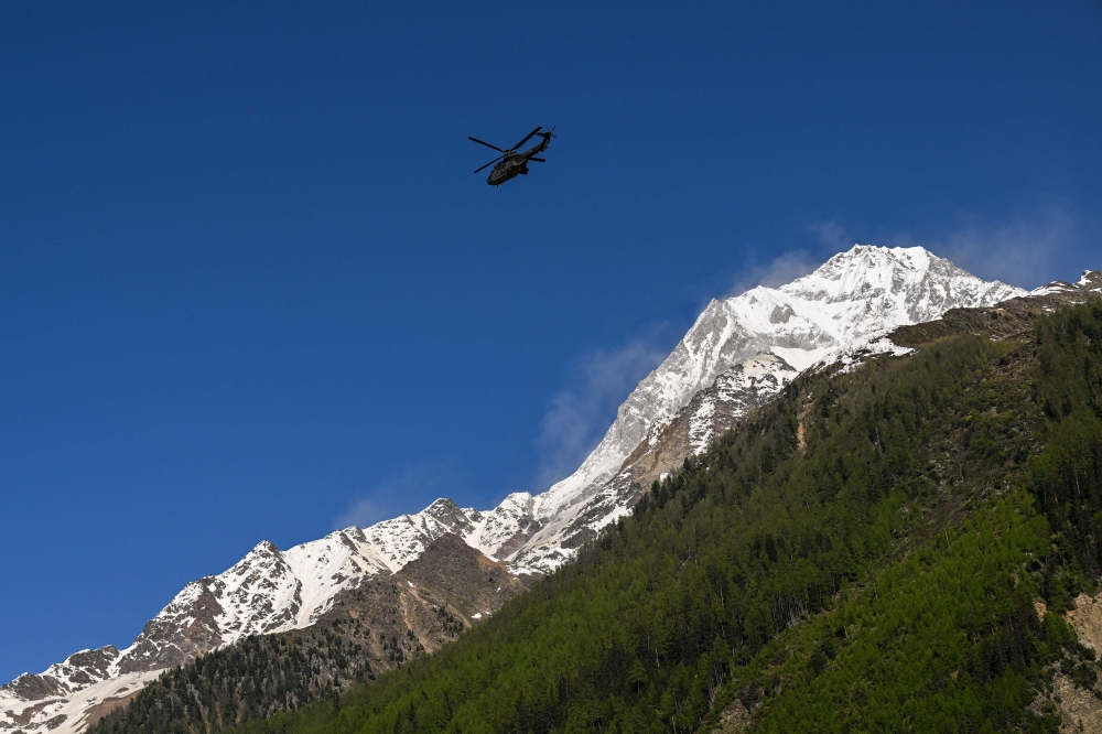 A Super Puma of Swiss air forces flies next to the Bietschhorn mountain above Wiler, on May 30, 2025, after the huge Birch Glacier collapsed. (Photo by Fabrice Coffrini / AFP)
 