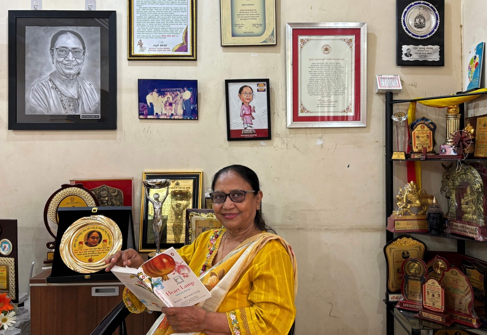 This photograph taken on May 31, 2025 shows Indian lawyer, activist and now International Booker Prize winner Banu Mushtaq posing with the book 'Heart Lamp' at her residence in Hassan, in India's Karnataka state. (Photo by Aishwarya Kumar / AFP)