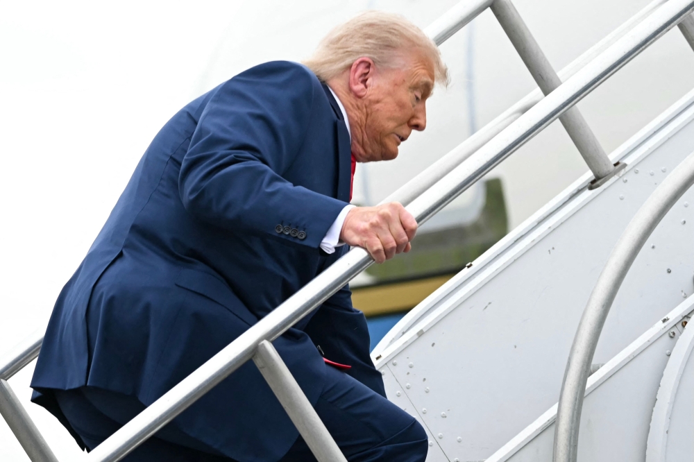 US President Donald Trump trips while boarding Air Force One prior to departure from Morristown Municipal Airport in Morristown, New Jersey, on June 8, 2025, en route to Camp David. (Photo by Andrew Caballero-Reynolds/ AFP)