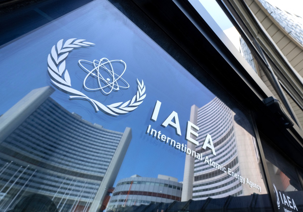 Buildings of the International Atomic Energy Agency (IAEA) headquarters reflect in doors with the agency's logo during the IAEA’s Board of Governors meeting in Vienna, Austria on June 13, 2025. Photo by Joe Klamar / AFP.
