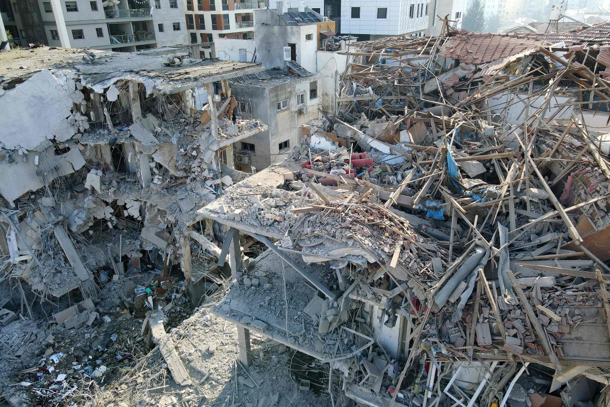 This aerial picture shows damaged buildings at a site hit by a missile fired from Iran in the Israeli city of Ramat Gan near Tel Aviv on June 14, 2025. (Photo by Jack GUEZ / AFP)
 