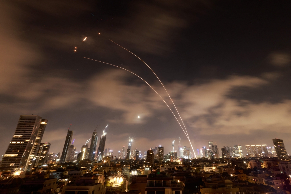 Israeli air defence systems are activated to intercept Iranian missiles over Tel Aviv early on June 18, 2025. (Photo by Menahem Kahana / AFP)
