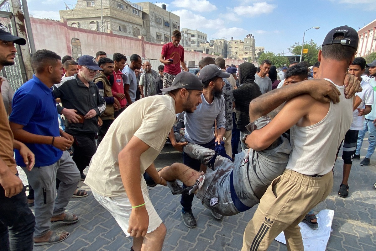 Palestinians transport a man who was injured in Israeli fire while waiting near a food aid centre, into Khan Yunis' Nasser hospital in the southern Gaza Strip on June 17, 2025. Photo by AFP