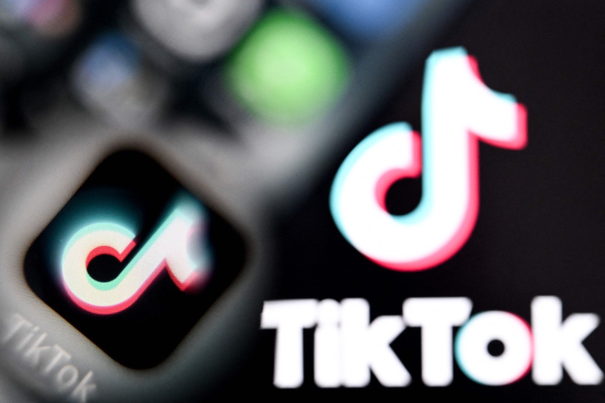 A photo taken on April 10, 2025 shows the Chinese social networking service TikTok's logos on a smartphone screen (L) and laptop screen in Frankfurt am Main, western Germany. Photo by Kirill KUDRYAVTSEV / AFP