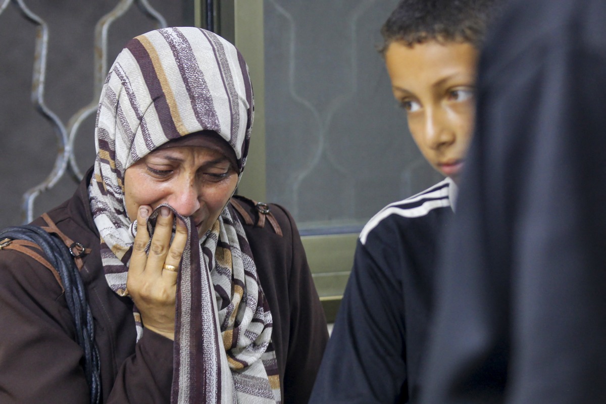 People mourn at the morgue of Al-Awda hospital, in Nuseirat camp in central Gaza on June 20, 2025. Photo by AFP