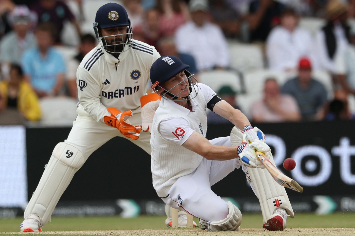 England's Harry Brook plays a sweep to the boundary while falling to the ground as India's wicket keeper Rishabh Pant (L) looks on on day three of the first cricket test match between England and India at Headingley cricket ground in Leeds, northern England on June 22, 2025. (Photo by Darren Staples / AFP) 