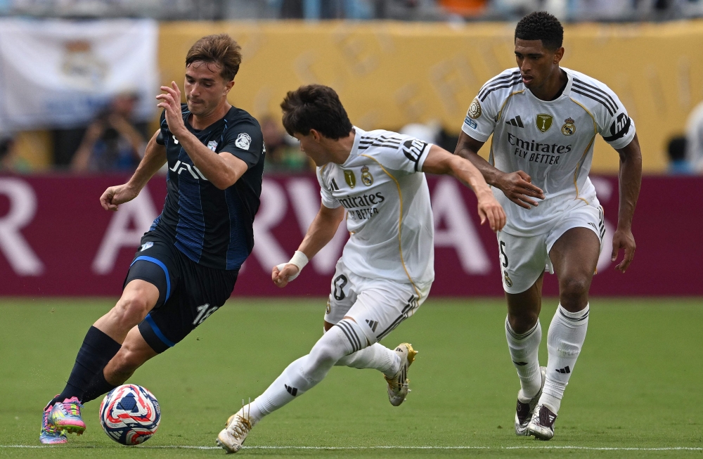 Pachuca's Argentine midfielder #18 Agustin Palavecino, Real Madrid's Spanish defender #20 Francisco Garcia and English midfielder #05 Jude Bellingham fight for the ball at the Bank of America stadium in Charlotte on June 22, 2025. (Photo by Federico Parra / AFP)