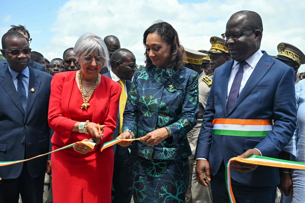 Swiss Interior Minister Elisabeth Baume-Schneider (second left) cuts an inaugural band flanked by Ivorian Minister of Culture and Francophonie Françoise Remarck (centre), Ivorian Minister of Health Pierre Demba (right) during the inauguration of an extension of Ivory Coast's first archaeological museum in the village of Singrobo-Ahouty near Tiassale on June 30, 2025. (Photo by Issouf Sanogo / AFP)