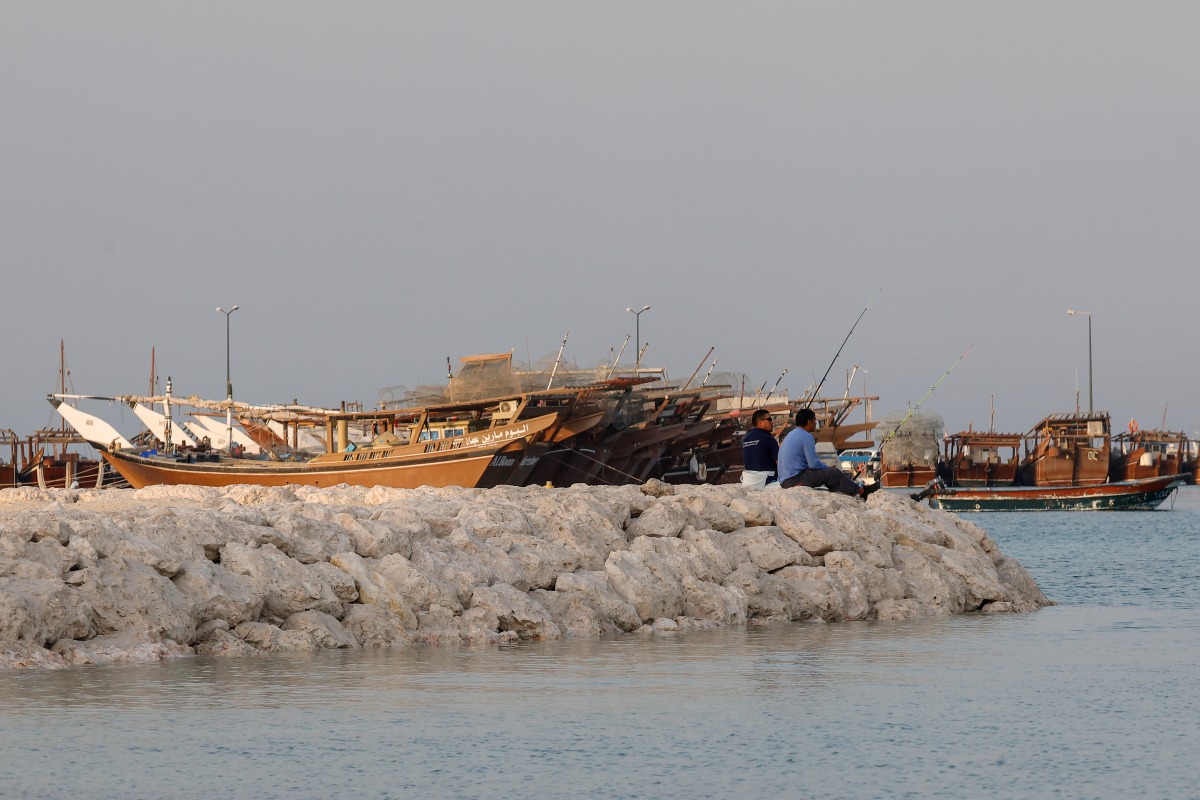 People fish in Doha on June 27, 2025. (Photo by Karim JAAFAR / AFP)