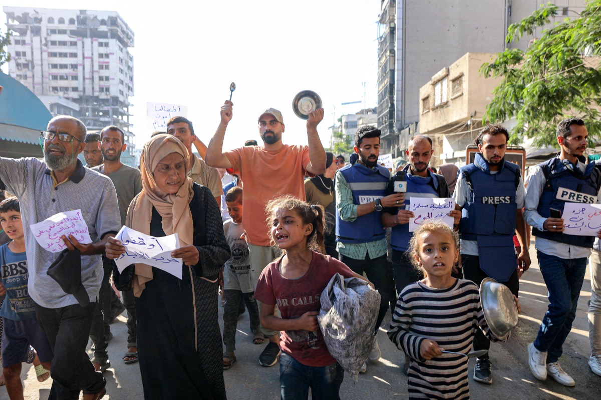 Demonstrators and journalists march in a protest against hunger in the Rimal district of Gaza City on July 19, 2025. (Photo by Omar AL-QATTAA / AFP)