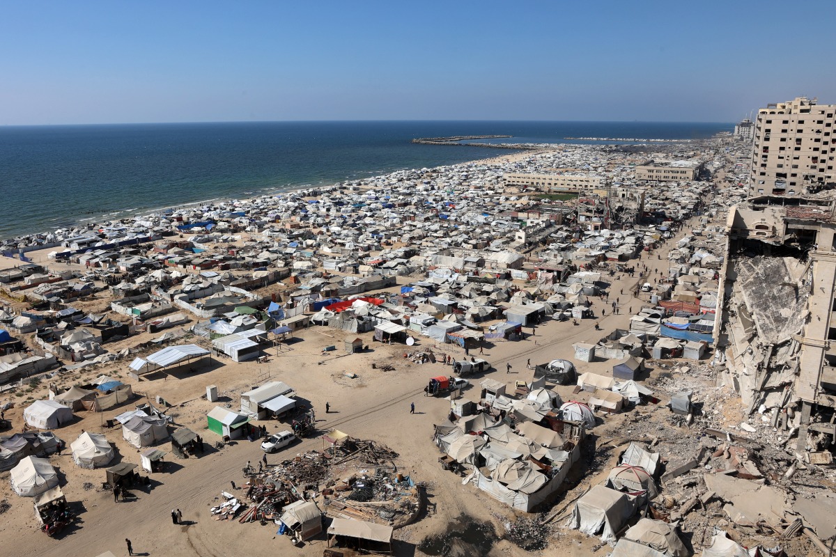 Tents and shelters for Palestinians displaced by conflict are pictured erected at a make-shift camp along the beach near the seaport in the west of Gaza City on July 19, 2025. (Photo by Omar AL-QATTAA / AFP)
