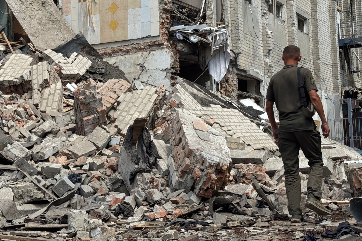 A Ukrainian law enforcement officer walks past a destroyed building of the Bilenkivska correctional colony following an air attack in Bilenke, Zaporizhzhia region on July 29, 2025. (Photo by Olexandr PAVLOV / AFP)
