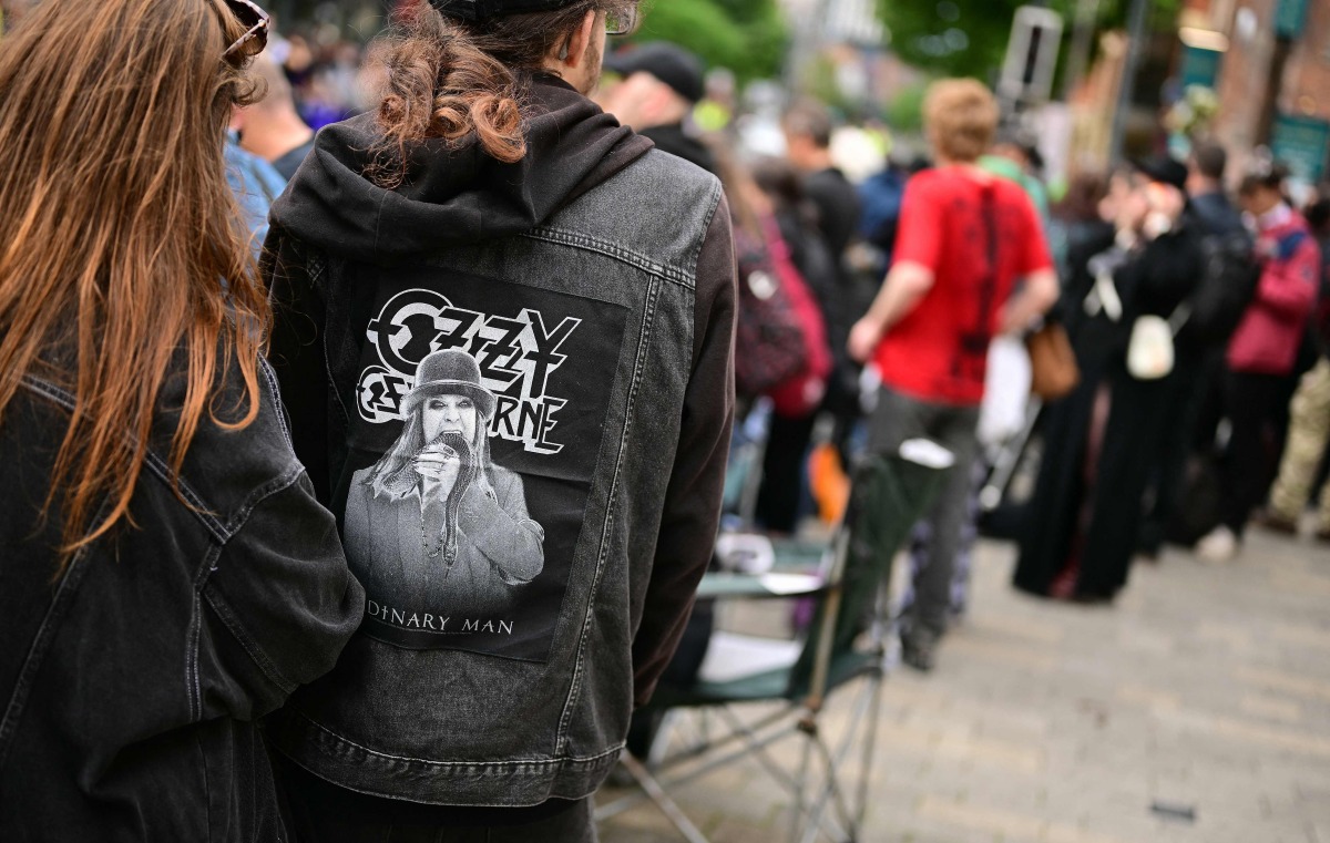 Mourners and music fans line the streets ready to pay their respects, before the funeral cortege of Ozzy Osbourne, the late lead singer of Black Sabbath, makes its way through Birmingham, central England on July 30, 2025. Photo by Ben STANSALL / AFP