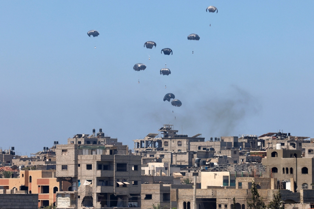 Aid pallets are parachuted after being dropped from a military plane over Nuseirat in the central Gaza Strip during an airdrop mission above the Israel-besieged Palestinian territory on August 4, 2025. (Photo by AFP)
