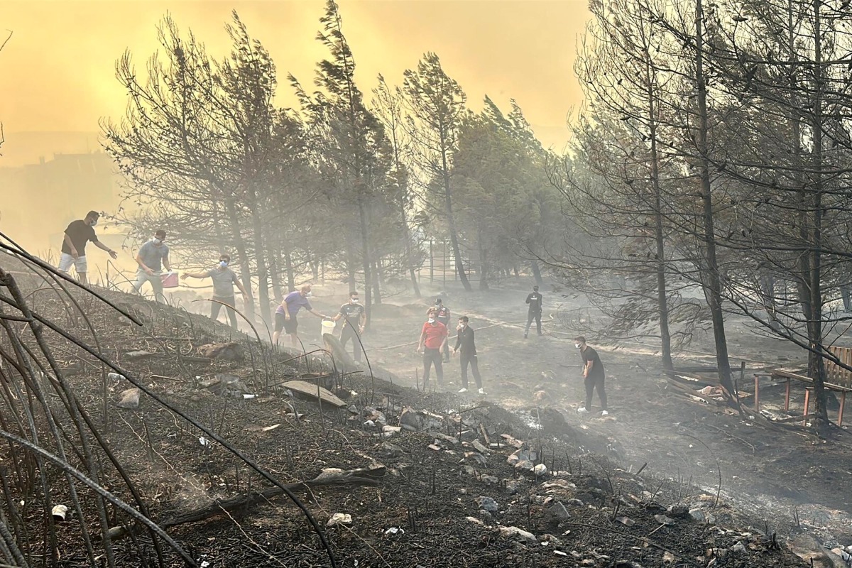 This handout photograph taken and released on August 8, 2025 by Turkish news agency DHA (Demiroren News Agency) shows people working to extinguish wildfire in Canakkale, northwestern Türkiye in the Marmara region. Photo by HANDOUT / DHA (Demiroren News Agency) / AFP.