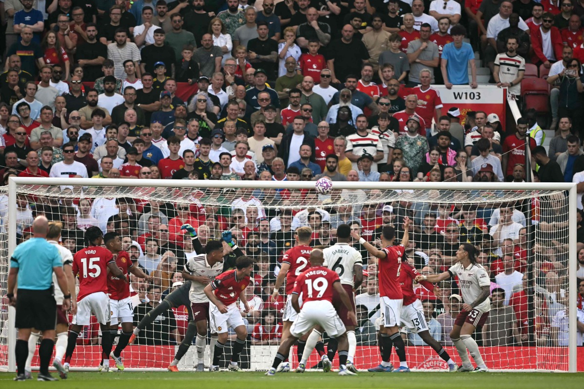 Manchester United's Turkish goalkeeper #01 Altay Bayindir is unable to reach the ball from an Arsenal corner as Arsenal's Italian defender #33 Riccardo Calafiori (R) prepares to head in the opening goal during the English Premier League football match between Manchester United and Arsenal at Old Trafford in Manchester, north west England, on August 17, 2025. (Photo by Paul ELLIS / AFP) 