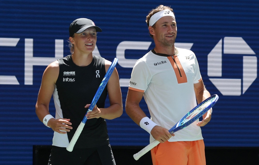 Poland's Iga Swiatek and Norway's Casper Ruud after a point against Madison Keys and Frances Tiafoe of the USA during their Mixed Doubles Match at the US Open tennis tournament at the USTA Billie Jean King National Tennis Center in New York City, on August 19, 2025. (Photo by Timothy A. Clary / AFP)