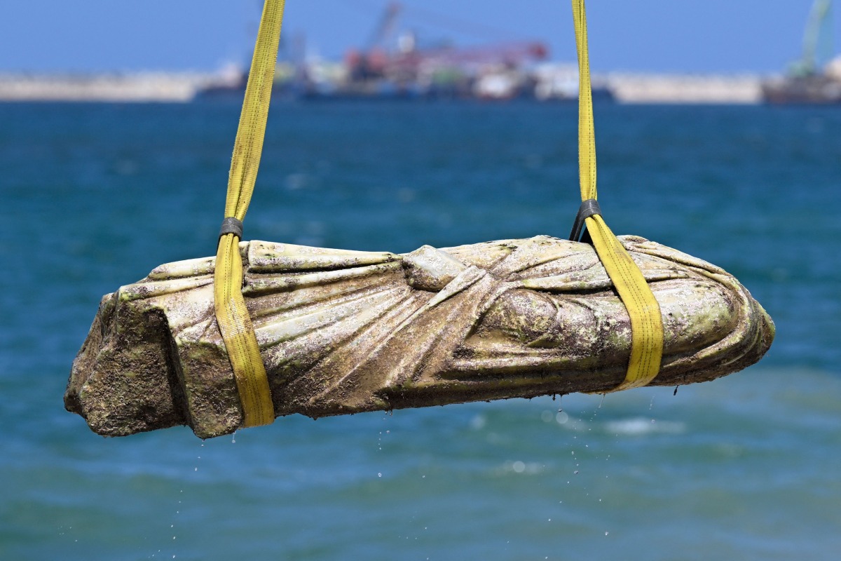 A crane pulls an artifact from the waters at Abu Qir bay in Alexandria on August 21, 2025, as part of an event organized by the Ministry of Tourism and Antiquities to recover sunken antiquities. (Photo by Khaled DESOUKI / AFP)