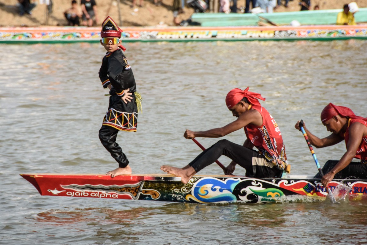 Rayyan Arkan Dikha (L), an 11-year-old boy who went viral for his calm dance on the bow of a traditional longboat, performs during the Pacu Jalur longboat race festival on the Kuantan River in Kuantan Singingi Regency, Riau Province, on August 21, 2025. Photo by Wahyudi / AFP