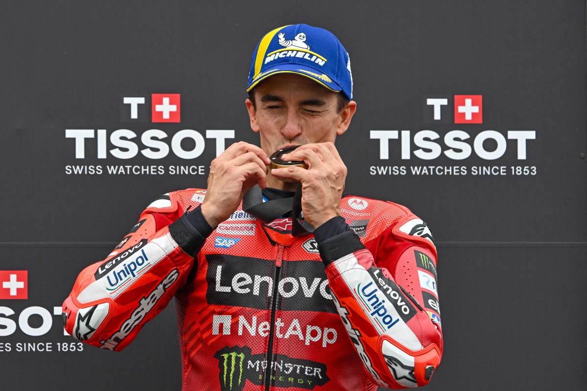 Ducati Lenovo Team's Spanish rider Marc Marquez kisses his gold medal as he celebrates his victory after the sprint race ahead of the motorcycle Hungarian Moto GP Grand Prix at the Balaton Park circuit in Balatonfokajar, Hungary, on August 23, 2025. (Photo by ATTILA KISBENEDEK / AFP)