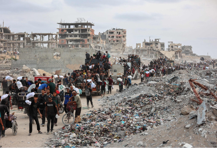 People try to get rice from a charity kitchen providing food for free in the west of Gaza City, on August 28, 2025. Photo by BASHAR TALEB / AFP