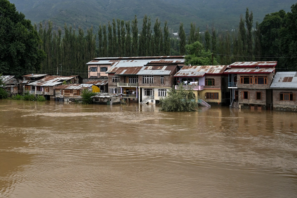 Partially submerged houses are pictured along the banks of the river Jhelum following heavy rains in Srinagar on August 28, 2025. Photo by Tauseef MUSTAFA / AFP.
