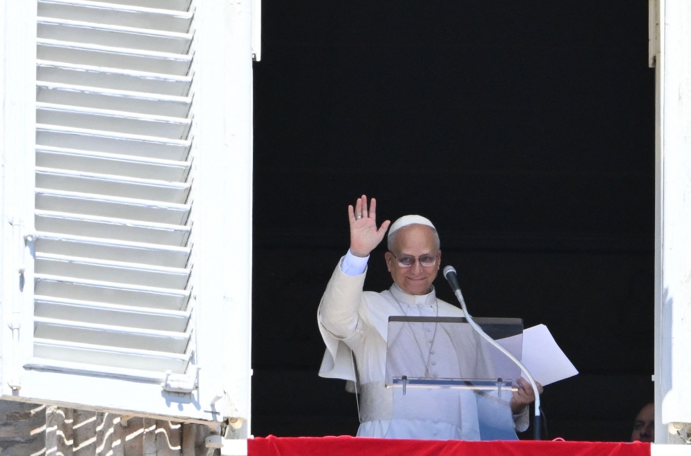 Pope Leo XIV salutes as he addresses the crowd from the window of the apostolic palace overlooking St.Peter's square on August 31, 2025. (Photo by Alberto Pizzoli / AFP)