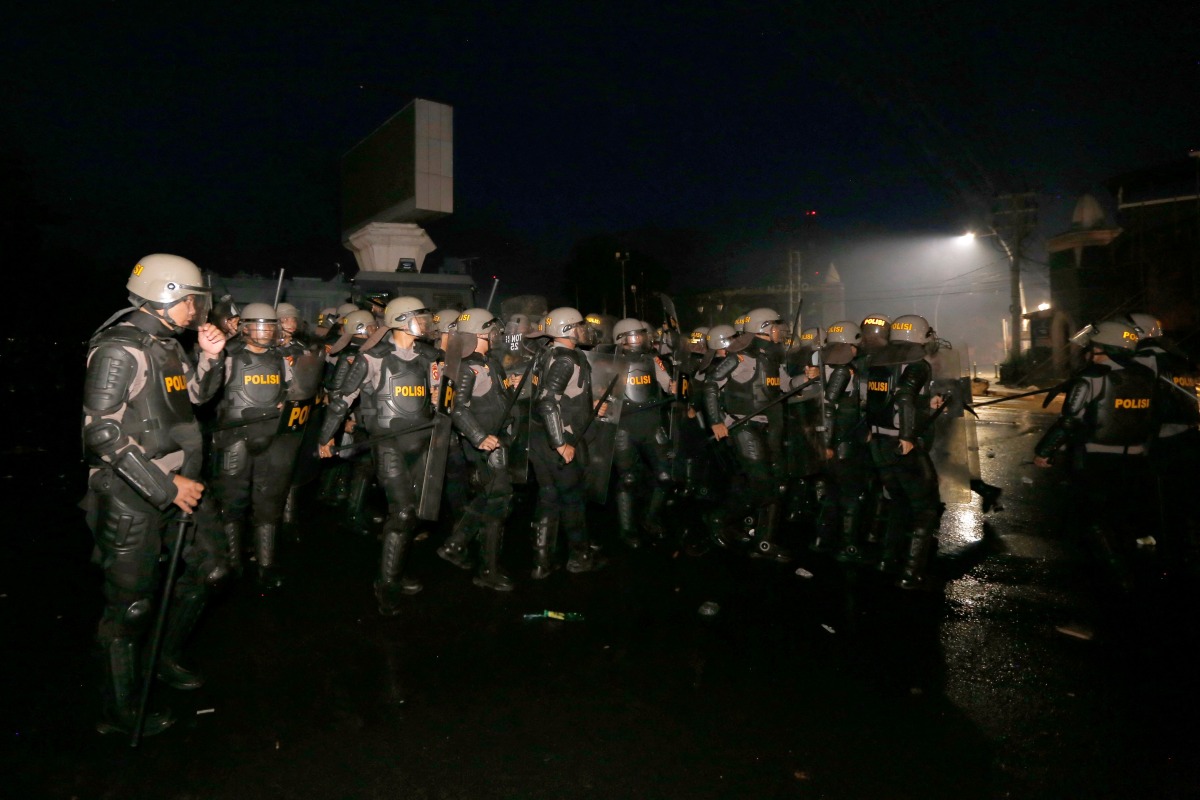 Police take a position to block protesters during a demonstration against higher lawmakers’ allowances and calling for the ratification of an asset confiscation bill in Gorontalo, Sulawesi, on September 1, 2025. (Photo by Dhidot / AFP)
