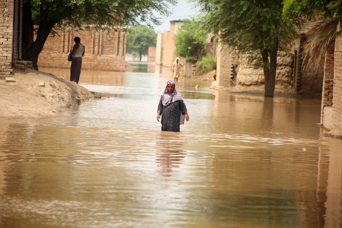 A woman wades through flood waters at a flood-hit area on the outskirts of Multan, Pakistan on Sept. 2, 2025. (Str/Xinhua)
