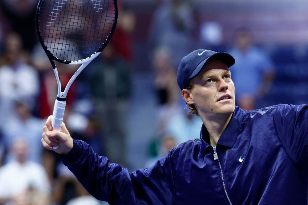 Italy's Jannik Sinner hits a ball to a fan after winning his men's singles semifinal tennis match against Canada's Felix Auger-Aliassime on September 5, 2025. (Photo by Kena Betancur / AFP)