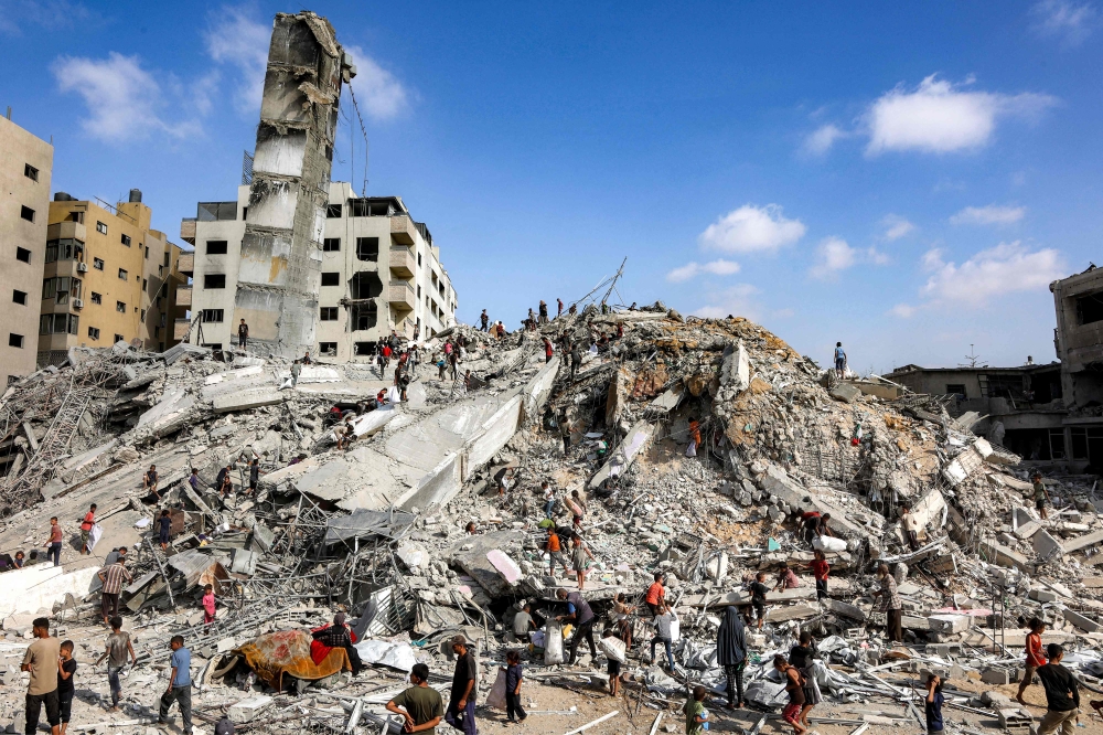 People search for salvage at the mound of rubble at the site of the collapsed Sussi Tower, which was destroyed earlier by Israeli bombardment, in Gaza City on September 6, 2025. (Photo by Omar Al-Qattaa / AFP)