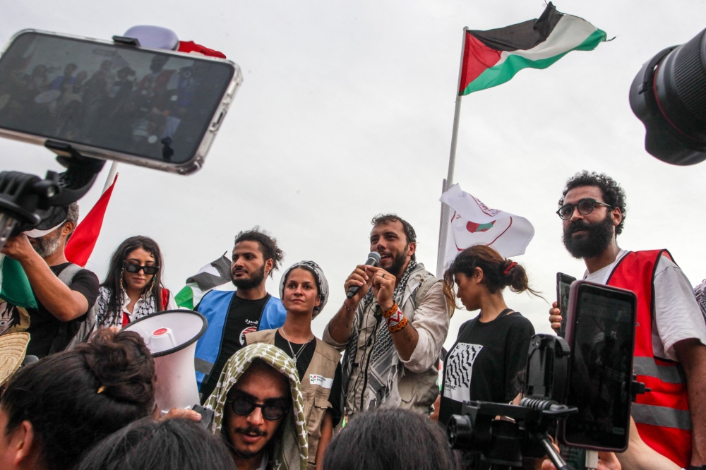 Brazilian activist Thiago Avila speaks to the crowd of pro-Palestinian activists that arrived to greet the Global Sumud Flottila at the port of the village of Sidi Bou Said on September 7, 2025. (Photo by Yassine Mahjoub / AFP)