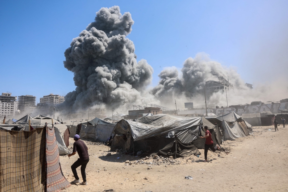 Smoke billows in Gaza City after Israeli strikes on a tower on September 10, 2025. (Photo by Omar Al-Qattaa / AFP)
