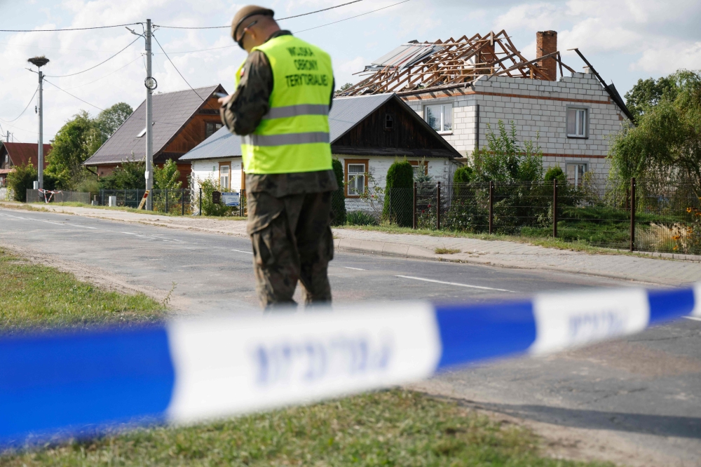Police and army inspect damage to a house destroyed by debris from a shot down Russian drone in the village of Wyryki-Wola, eastern Poland, on September 10, 2025. (Photo by Wojtek Radwanski / AFP)