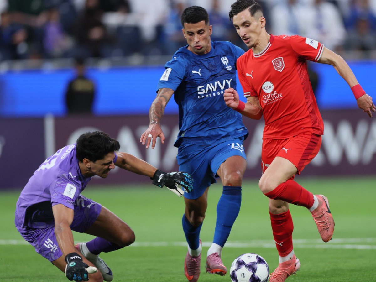 Al Duhail's Adil Boulbina (right) prepares to score a goal against Al Hilal.