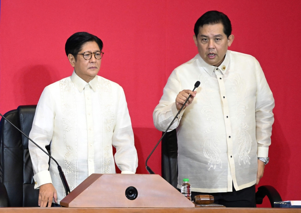 This photo taken on July 28, 2025 shows Philippine President Ferdinand Marcos (left) listening to Speaker of the House Martin Romualdez in the upper rostrum during the State of the Nation Address at the House of Representatives in Manila. (Photo by Ted Aljibe / AFP)
